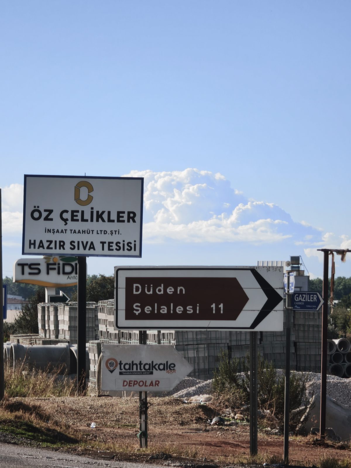 Yol kenarında 'Düden Şelalesi 11' yazılı kahverengi yön tabelası